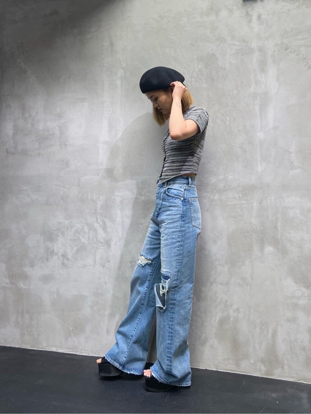 ブルー系のデニムパンツ、ブラック系のニット/セーター、ブラック系のハンチング/ベレー帽を着用したレディースの夏コーディネートの3枚目の写真