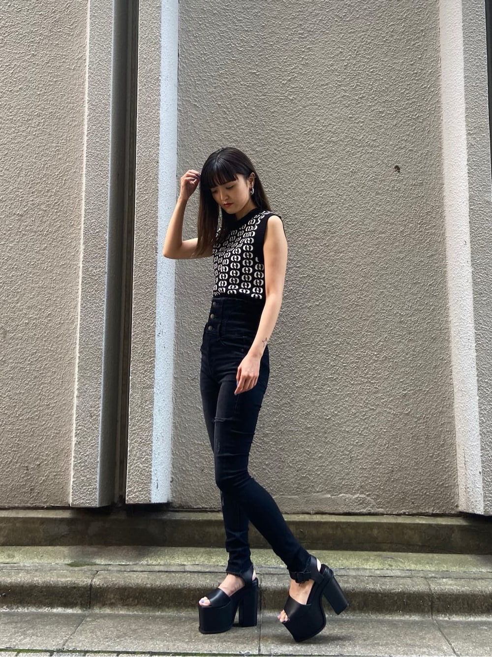 ブラック系のサンダル、その他のタンクトップ、ブラック系のデニムパンツを着用したレディースの春コーディネートの2枚目の写真