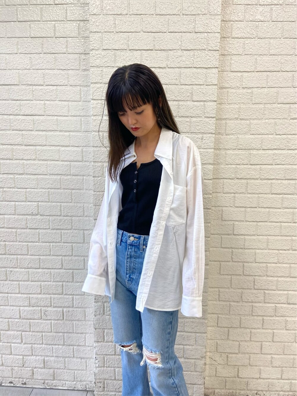 ブルー系のデニムパンツ、ブラック系のサンダル、ホワイト系のシャツ/ブラウスを着用したレディースの夏コーディネートの4枚目の写真