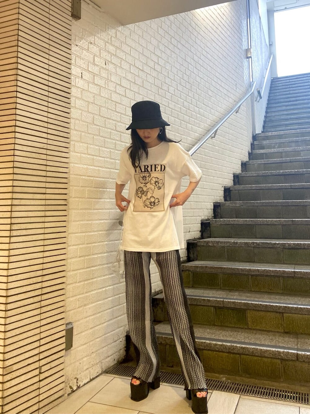 ブラック系のサンダル、その他のその他パンツ、ホワイト系のTシャツ/カットソーを着用したレディースの春コーディネートの2枚目の写真