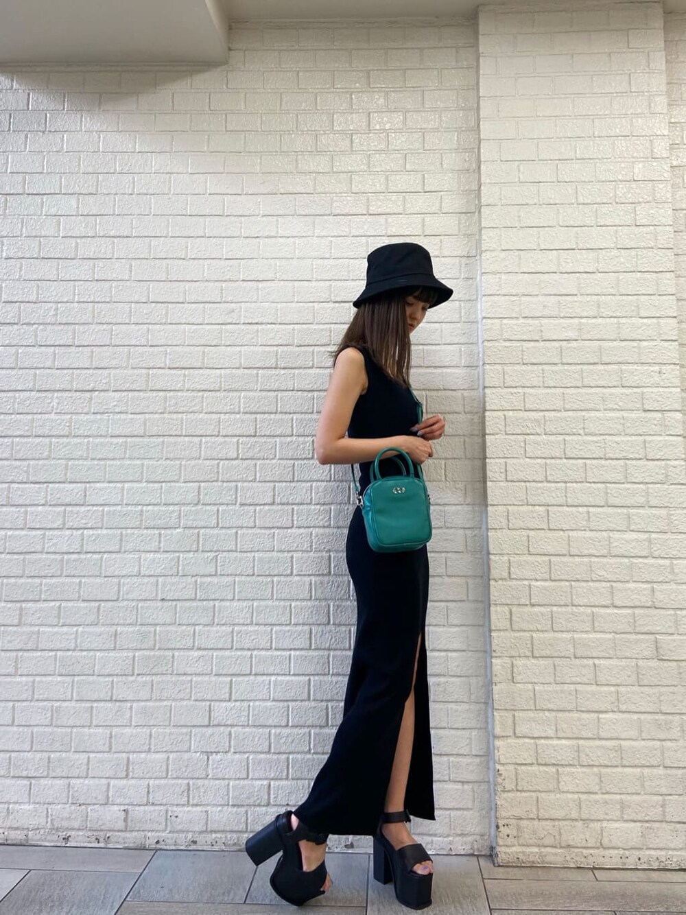 ブラック系のサンダル、ブルー系のショルダーバッグ、ブラック系のワンピースを着用したレディースの春コーディネートの2枚目の写真