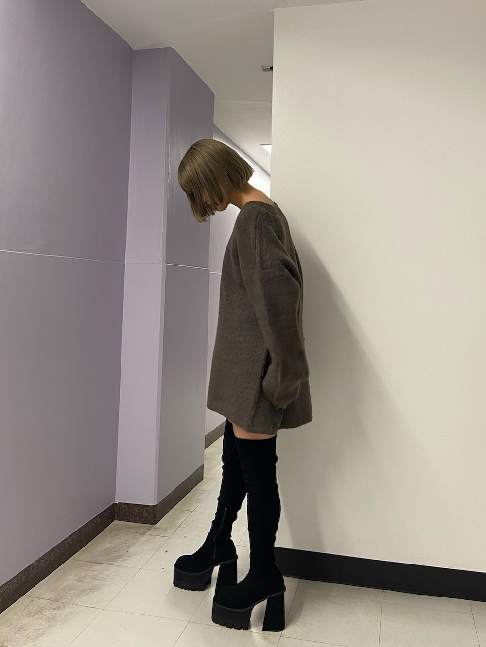 ブラウン系のニット/セーター、ブラック系のスカート、ブラック系のブーツを着用したレディースの冬コーディネートの3枚目の写真