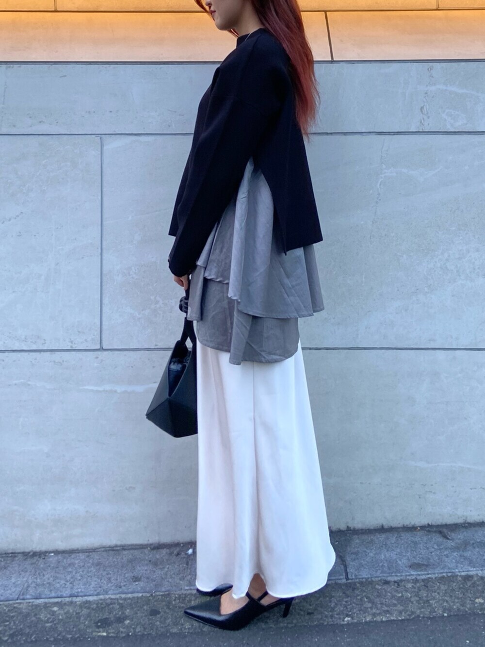 ブラック系のサンダル、ブラック系のニット/セーター、ホワイト系のスカートを着用したレディースの秋コーディネートの2枚目の写真