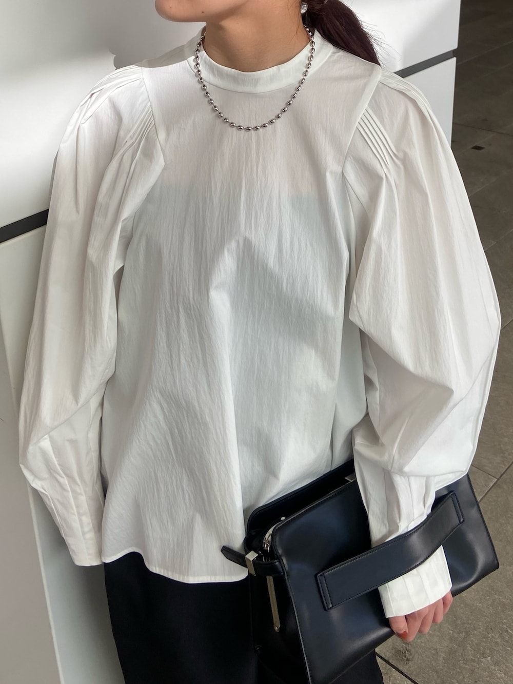 ホワイト系のシャツ/ブラウス、ブラック系のその他パンツ、ブラック系のハンドバッグを着用したレディースの冬コーディネートの4枚目の写真