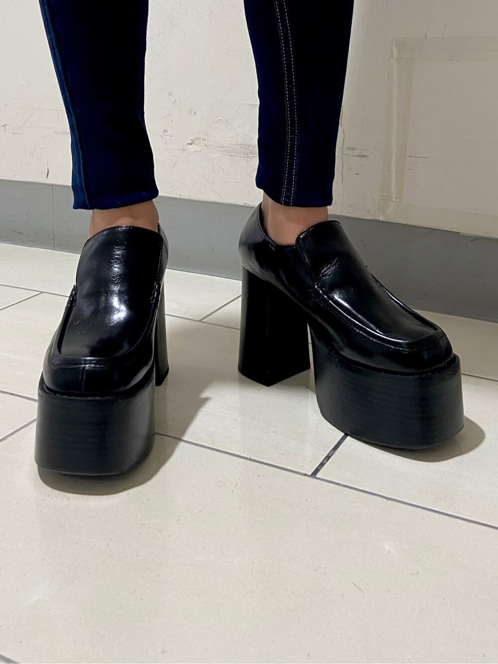 ブラック系のローファー、グリーン系のニット/セーター、ブラック系のデニムパンツを着用したレディースの冬コーディネートの5枚目の写真