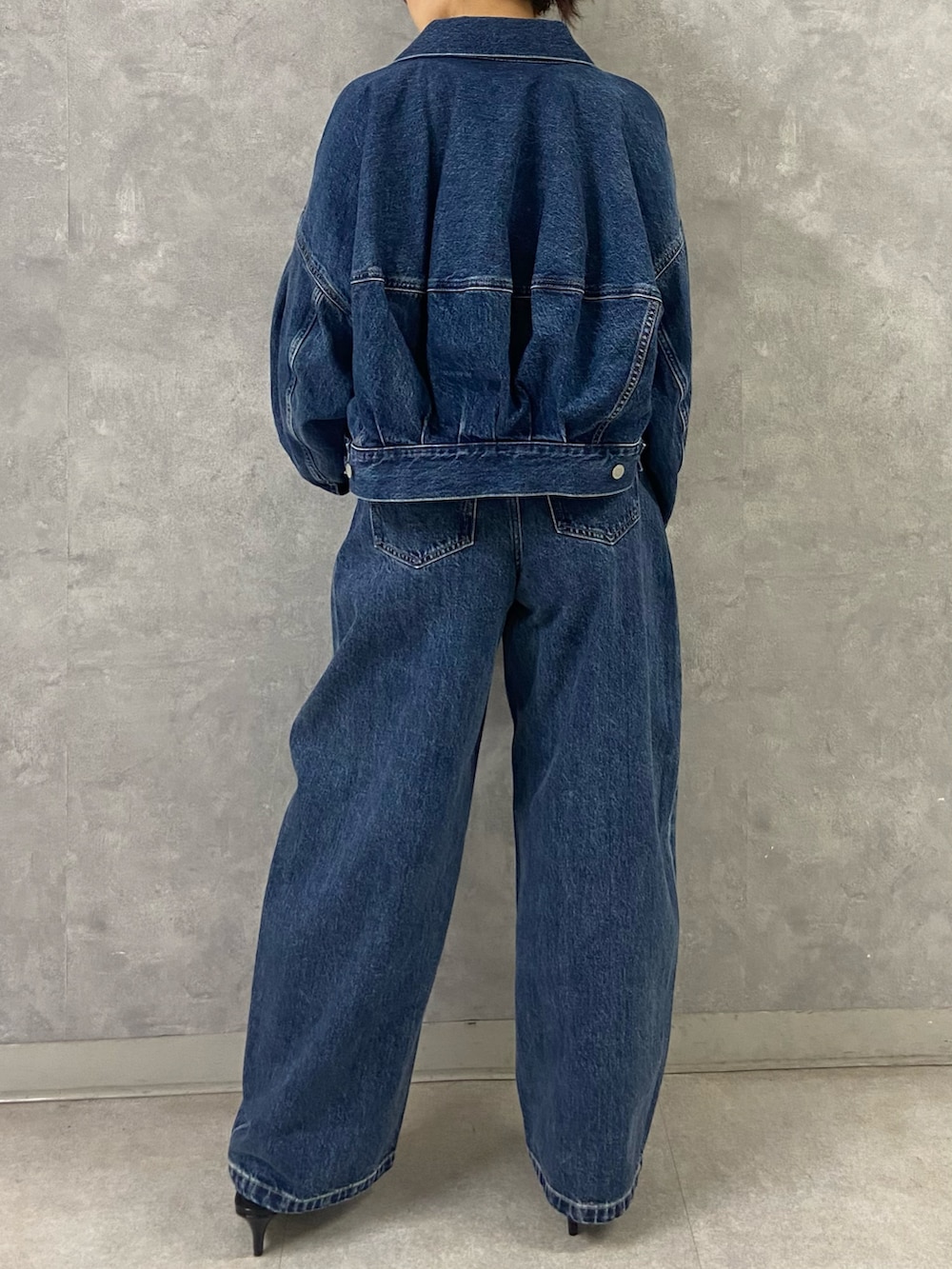 ブルー系のデニムジャケット、シルバー系のキャミソール、ブルー系のデニムパンツを着用したレディースの春コーディネートの4枚目の写真