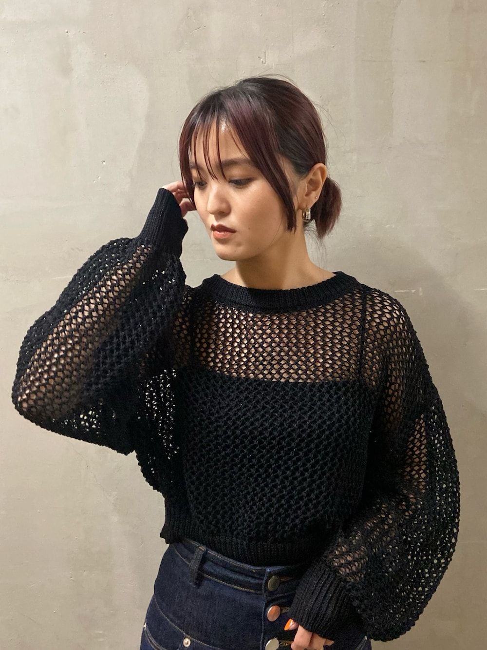 ブラック系のニット/セーター、ブルー系のデニムパンツ、ブラック系のサンダルを着用したレディースの春コーディネートの3枚目の写真