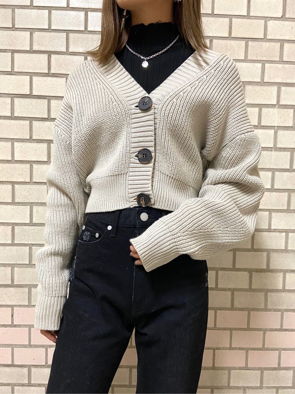 ブラック系のローファー、ブラック系のニット/セーター、ベージュ系のカーディガン/ボレロを着用したレディースの冬コーディネートの2枚目の写真