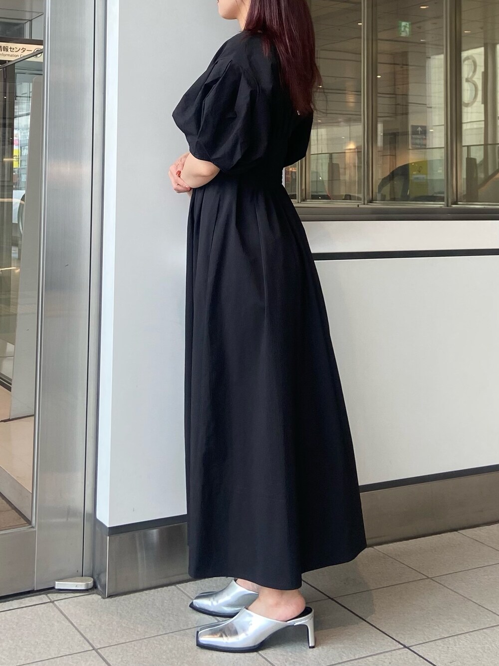 ブラック系のワンピース、ブラック系のショルダーバッグ、シルバー系のサンダルを着用したレディースの春コーディネートの3枚目の写真