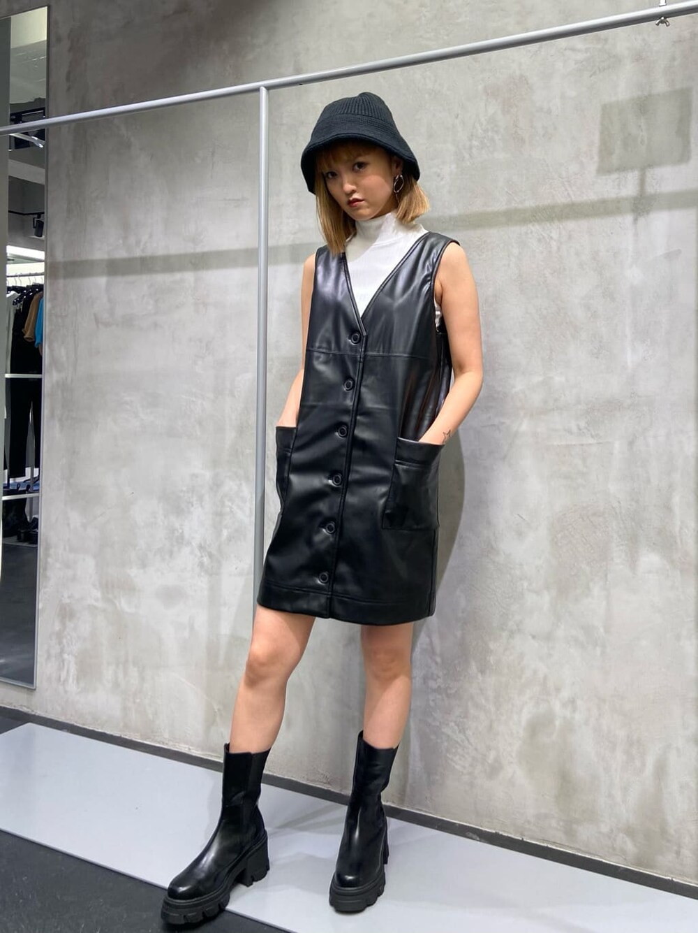 ブラック系のワンピース、ブラック系のブーツ、ホワイト系のTシャツ/カットソーを着用したレディースの夏コーディネートの2枚目の写真