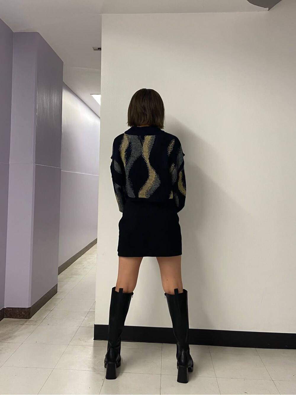 ブラック系のブーツ、ブラック系のスカート、ブラック系のテーラードジャケットを着用したレディースの秋コーディネートの7枚目の写真