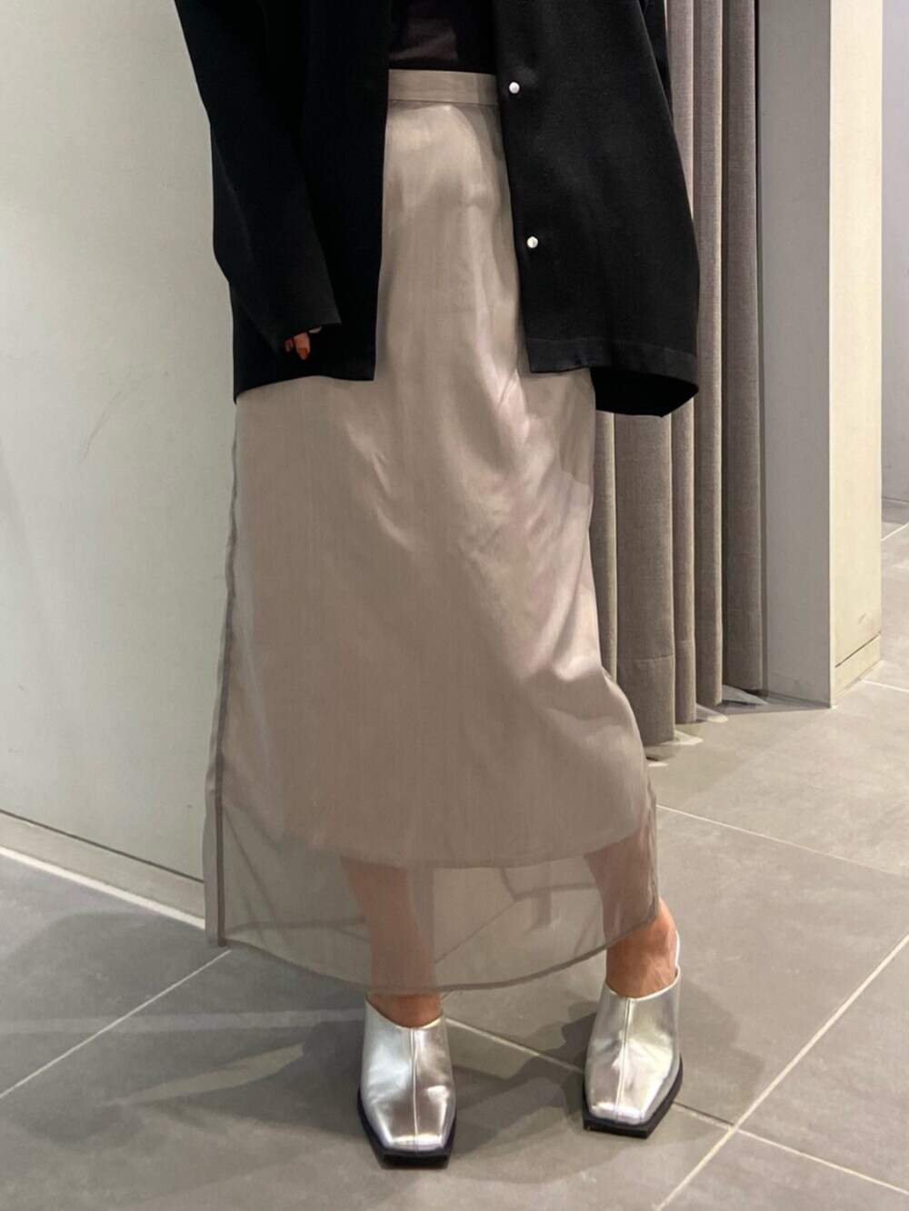 シルバー系のサンダル、ブラック系のカーディガン/ボレロ、ベージュ系のスカートを着用したレディースの冬コーディネートの5枚目の写真