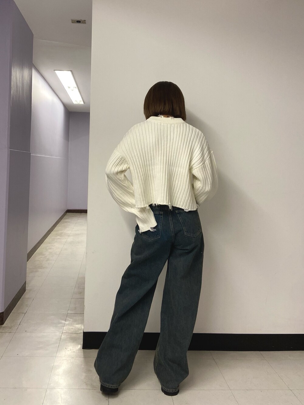 ホワイト系のニット/セーター、ブルー系のデニムパンツ、ブラック系のブーツを着用したレディースの秋コーディネートの3枚目の写真