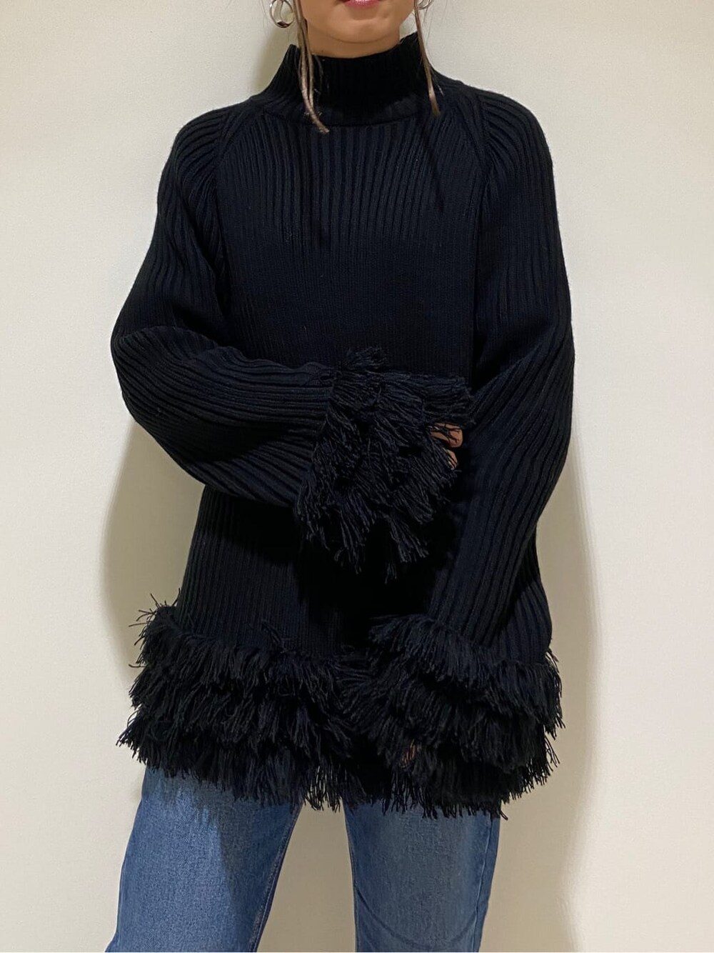 ブラック系のブーツ、ブルー系のデニムパンツ、ブラック系のニット/セーターを着用したレディースの冬コーディネートの3枚目の写真