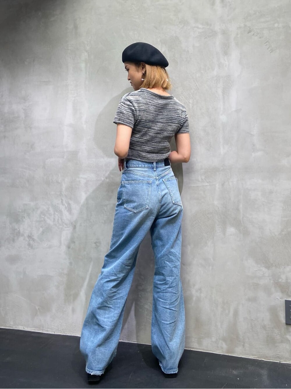 ブルー系のデニムパンツ、ブラック系のニット/セーター、ブラック系のハンチング/ベレー帽を着用したレディースの夏コーディネートの4枚目の写真