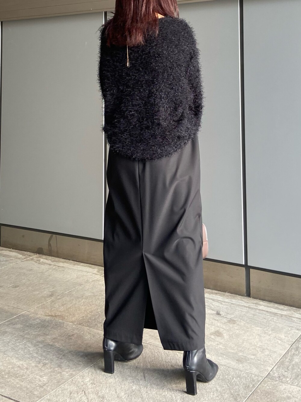 ブラック系のスカート、ブラウン系のボストンバッグ、ブラック系のブーツを着用したレディースの冬コーディネートの7枚目の写真