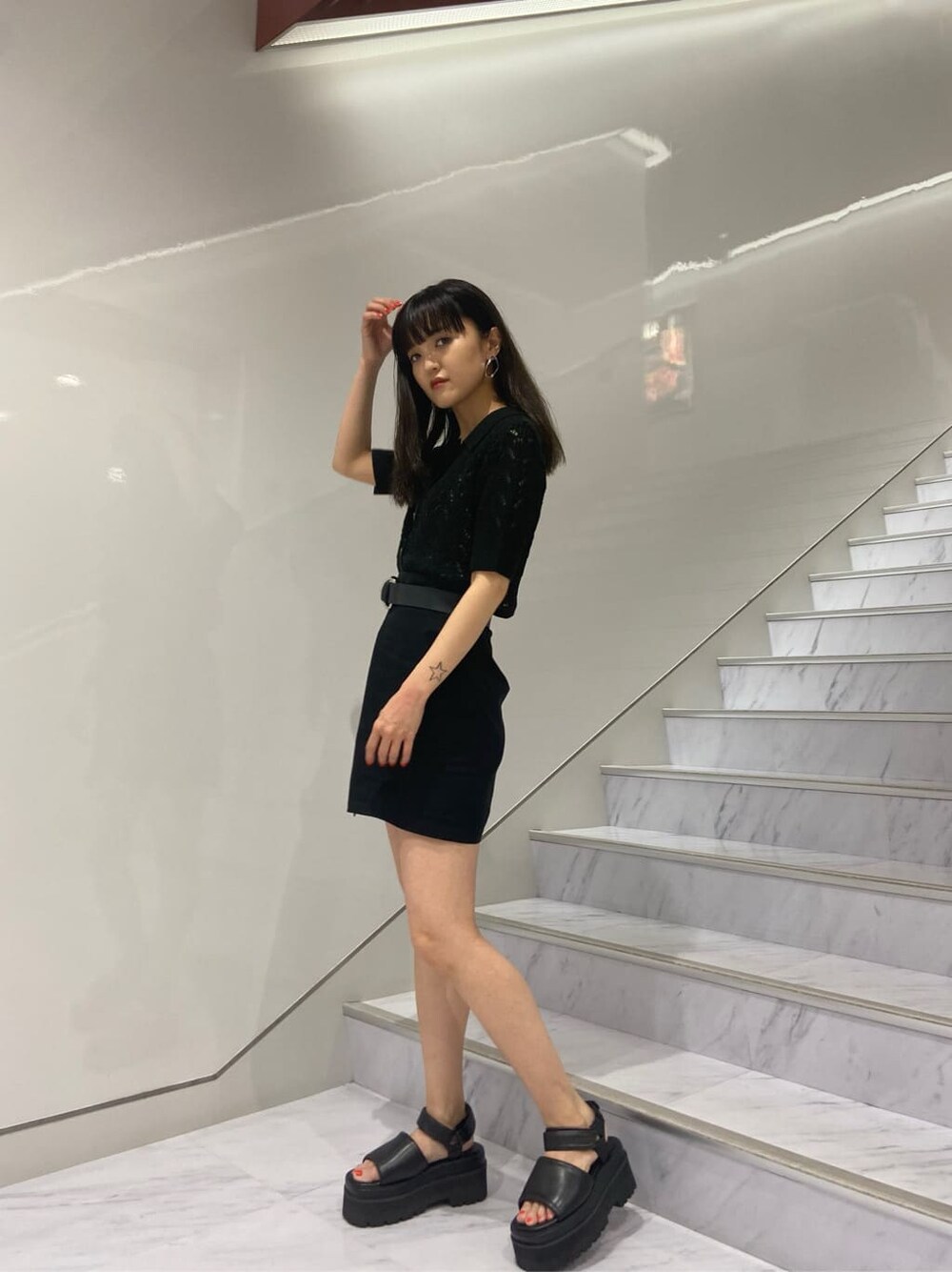 ブラック系のサンダル、ブラック系のニット/セーター、ブラック系のスカートを着用したレディースの夏コーディネートの2枚目の写真