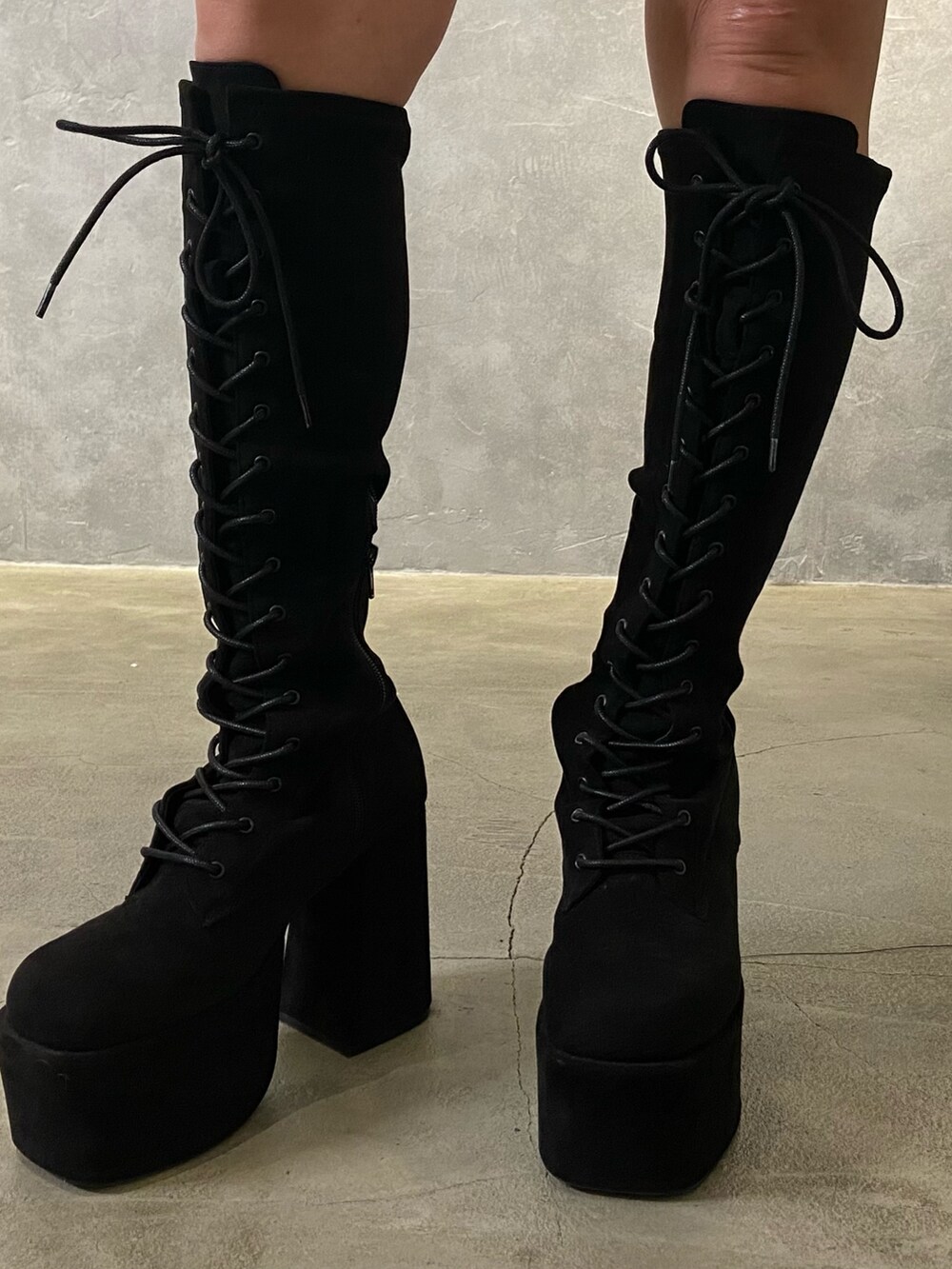 ブラック系のTシャツ/カットソー、ブラック系のスカート、ブラック系のブーツを着用したレディースの冬コーディネートの7枚目の写真