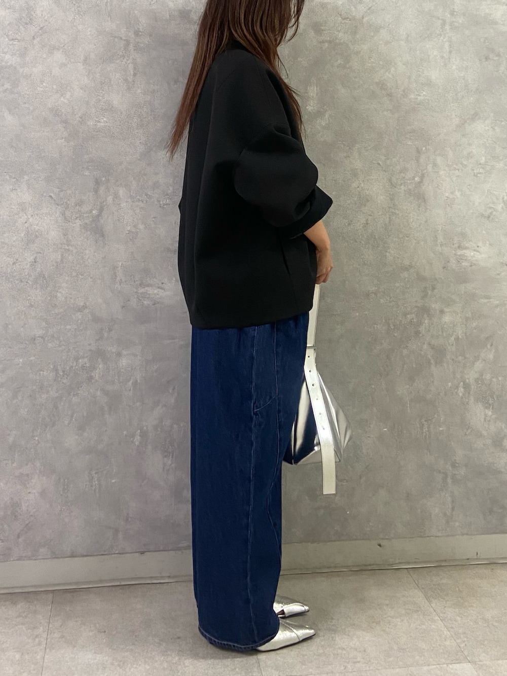 ブラック系のその他アウター、ホワイト系のTシャツ/カットソー、ブルー系のデニムパンツを着用したレディースの冬コーディネートの5枚目の写真