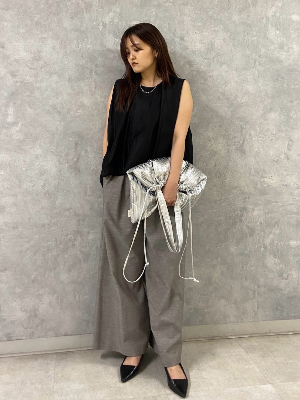 ブラック系のシャツ/ブラウス、シルバー系のトートバッグ、ブラウン系のその他パンツを着用したレディースの春コーディネートの2枚目の写真