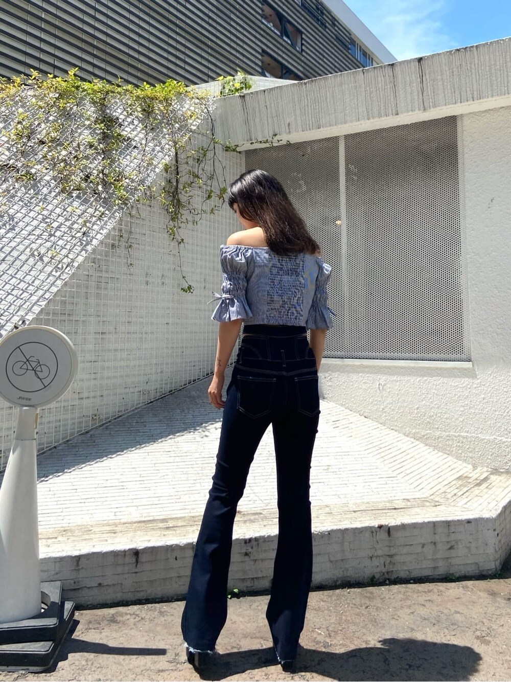 ブラック系のサンダル、ブルー系のデニムパンツ、グレー系のシャツ/ブラウスを着用したレディースの夏コーディネートの3枚目の写真