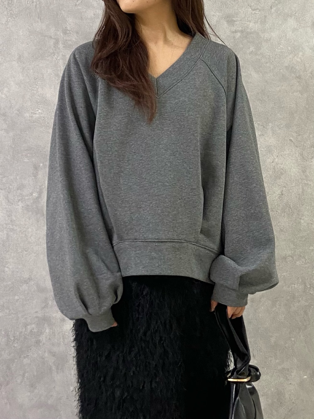 グレー系のTシャツ/カットソー、ブラック系のスカート、シルバー系のローファーを着用したレディースの冬コーディネートの5枚目の写真