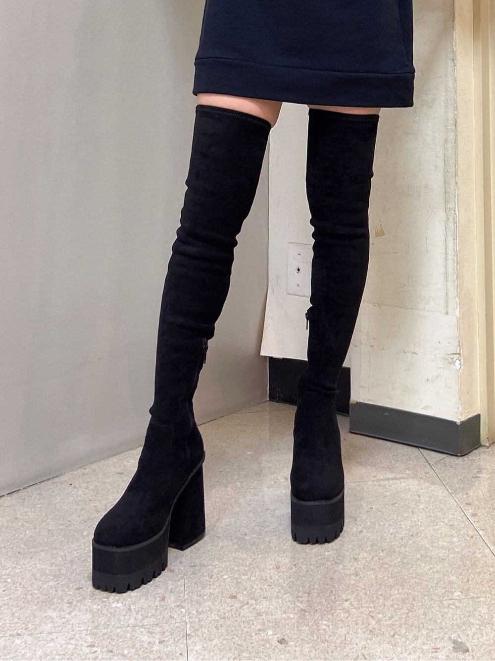 ブラック系のワンピース、ブラック系のブーツを着用したレディースの秋コーディネートの4枚目の写真