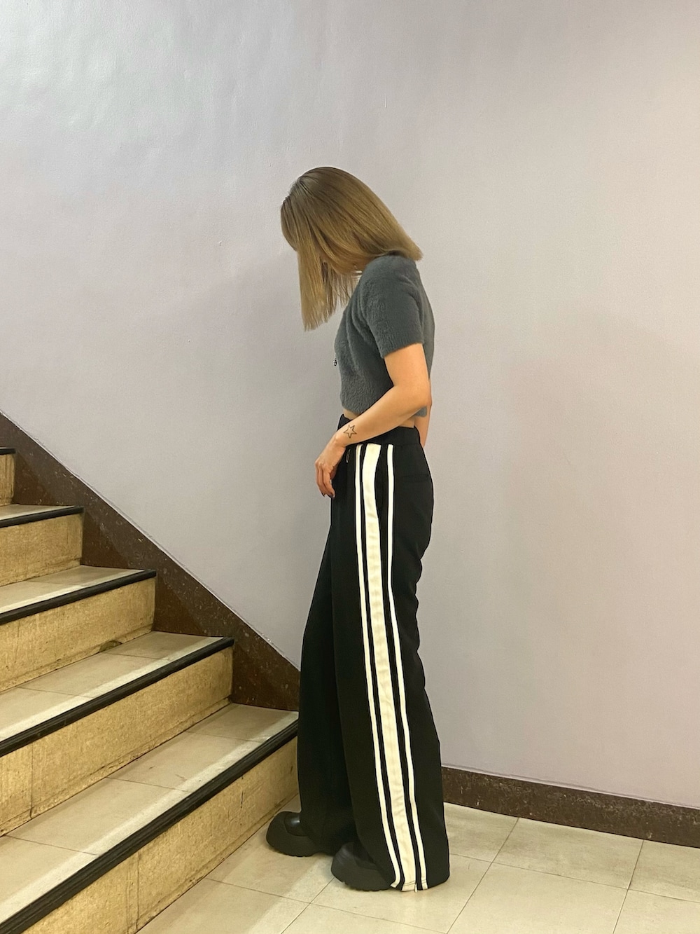 グレー系のニット/セーター、ブラック系のその他パンツ、ブラック系のブーツを着用したレディースの夏コーディネートの3枚目の写真