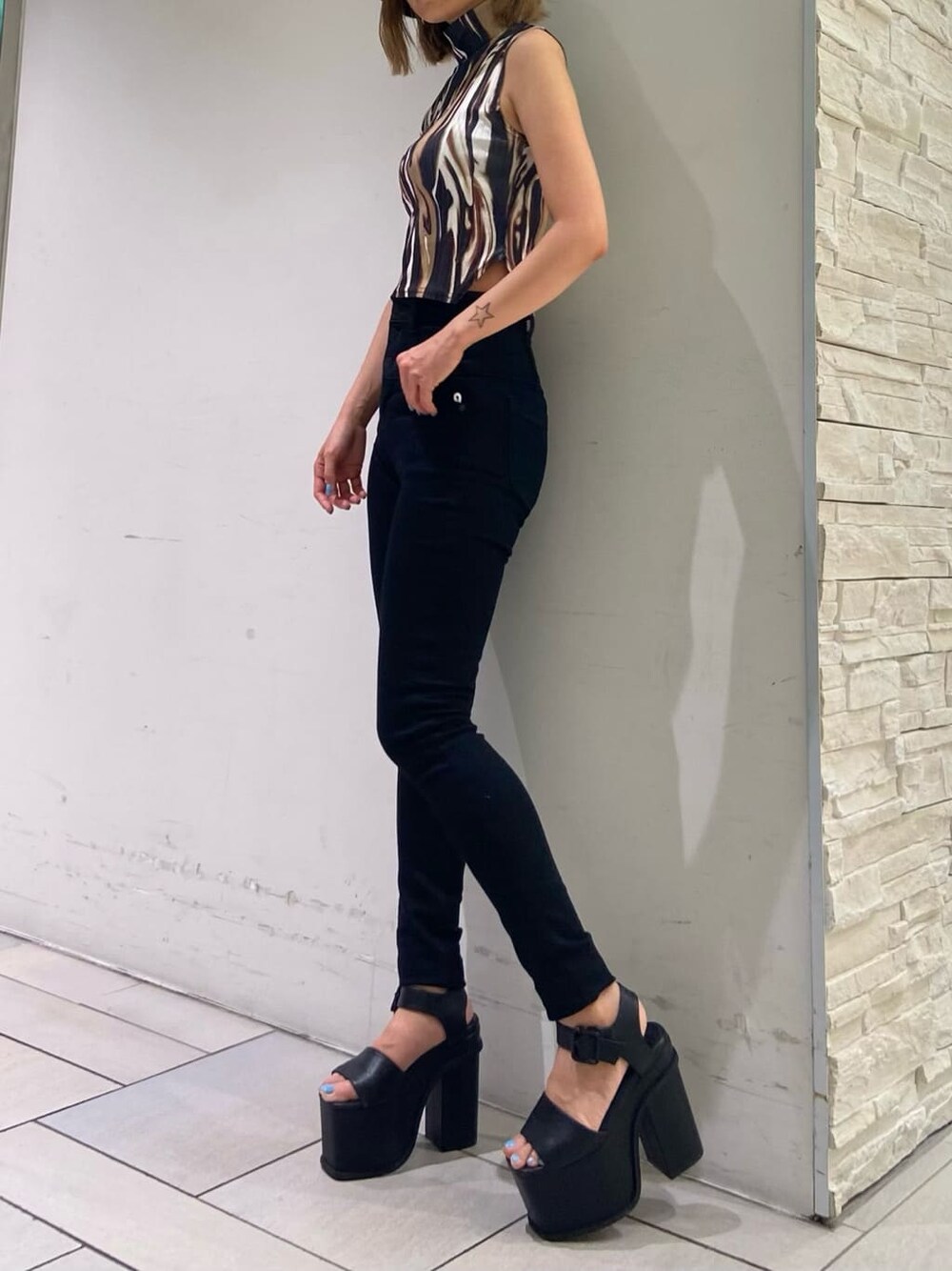 ブラック系のデニムパンツ、ブラック系のサンダル、その他のTシャツ/カットソーを着用したレディースの夏コーディネートの3枚目の写真