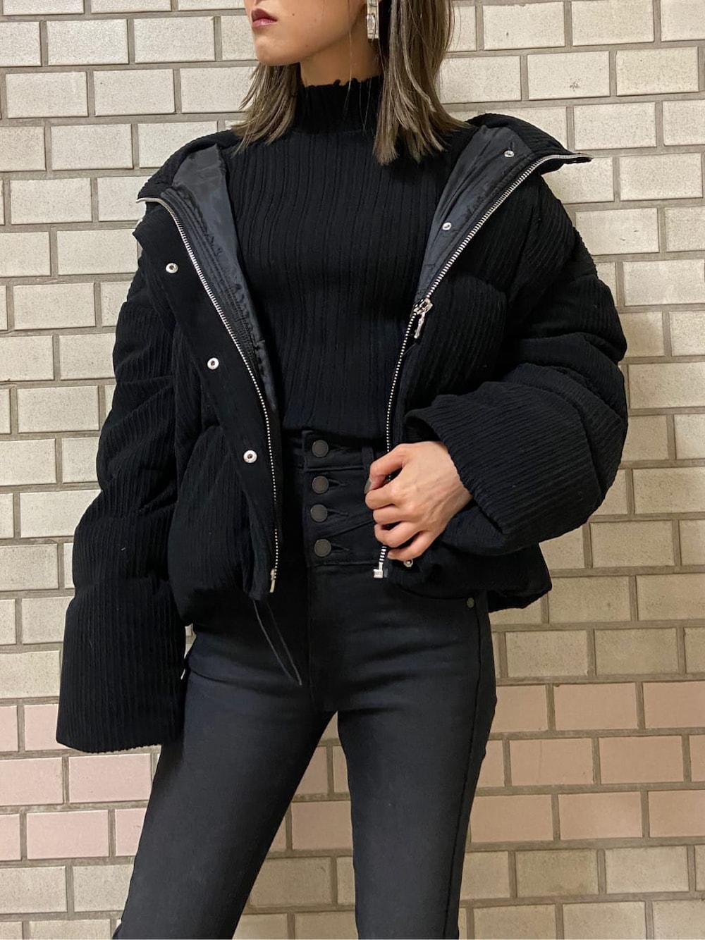 ブラック系のブーツ、ブラック系のニット/セーター、ブラック系のダウンジャケット/コートを着用したレディースの冬コーディネートの3枚目の写真