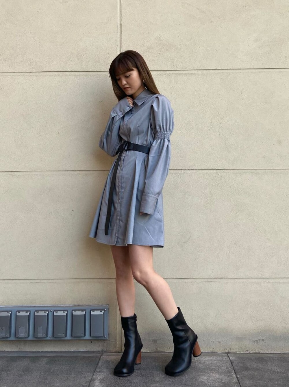 ブラック系のブーツ、グレー系のワンピース、シルバー系のピアス（両耳用）を着用したレディースの春コーディネートの2枚目の写真
