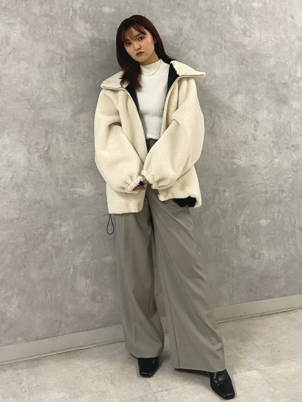 ホワイト系のその他アウター、ホワイト系のニット/セーター、グレー系のその他パンツを着用したレディースの秋コーディネートの6枚目の写真