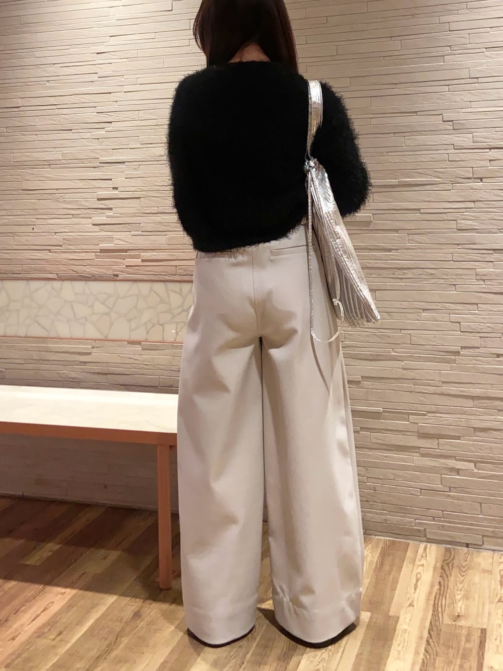 ブラック系のニット/セーター、ホワイト系のその他パンツ、ブラック系のパンプスを着用したレディースの冬コーディネートの3枚目の写真