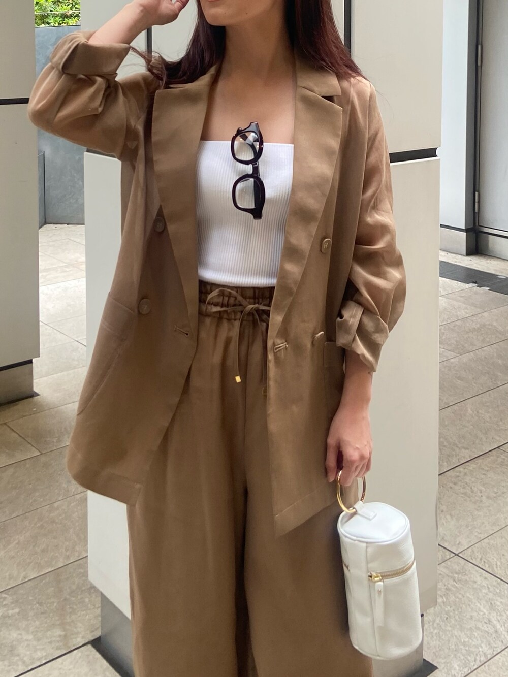 ブラウン系のその他パンツ、ブラック系のサンダル、ホワイト系のキャミソールを着用したレディースの春コーディネートの5枚目の写真