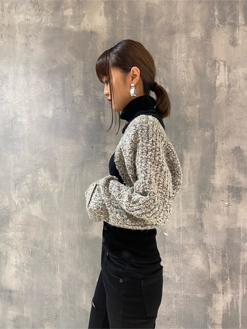 ブラック系のローファー、ブラック系のニット/セーター、ブラック系のデニムパンツを着用したレディースの秋コーディネートの4枚目の写真