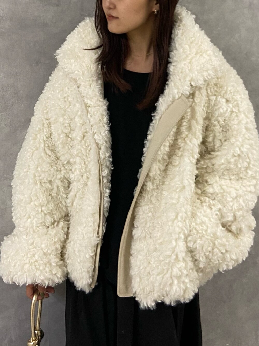 ホワイト系のブルゾン、ブラック系のワンピース、ブラック系のブーツを着用したレディースの冬コーディネートの4枚目の写真