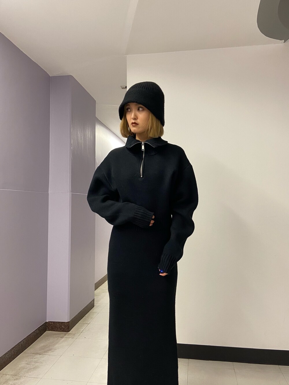 ブラック系のニット/セーター、ブラウン系のブーツ、ブラック系のスカートを着用したレディースの冬コーディネートの6枚目の写真