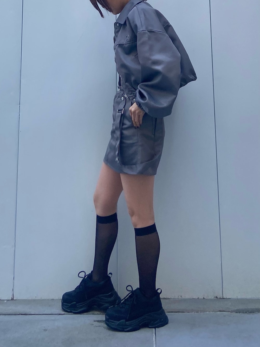 グレー系のブルゾン、ブラック系のキャミソール、グレー系のスカートを着用したレディースの冬コーディネートの2枚目の写真