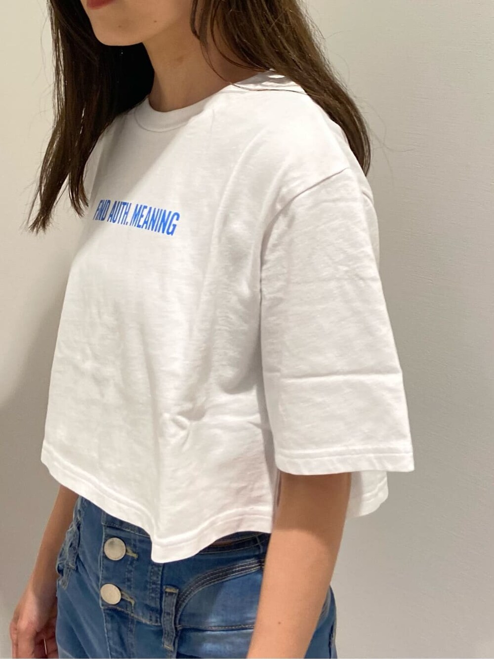 ブルー系のデニムパンツ、ブラック系のサンダル、ホワイト系のTシャツ/カットソーを着用したレディースの夏コーディネートの6枚目の写真