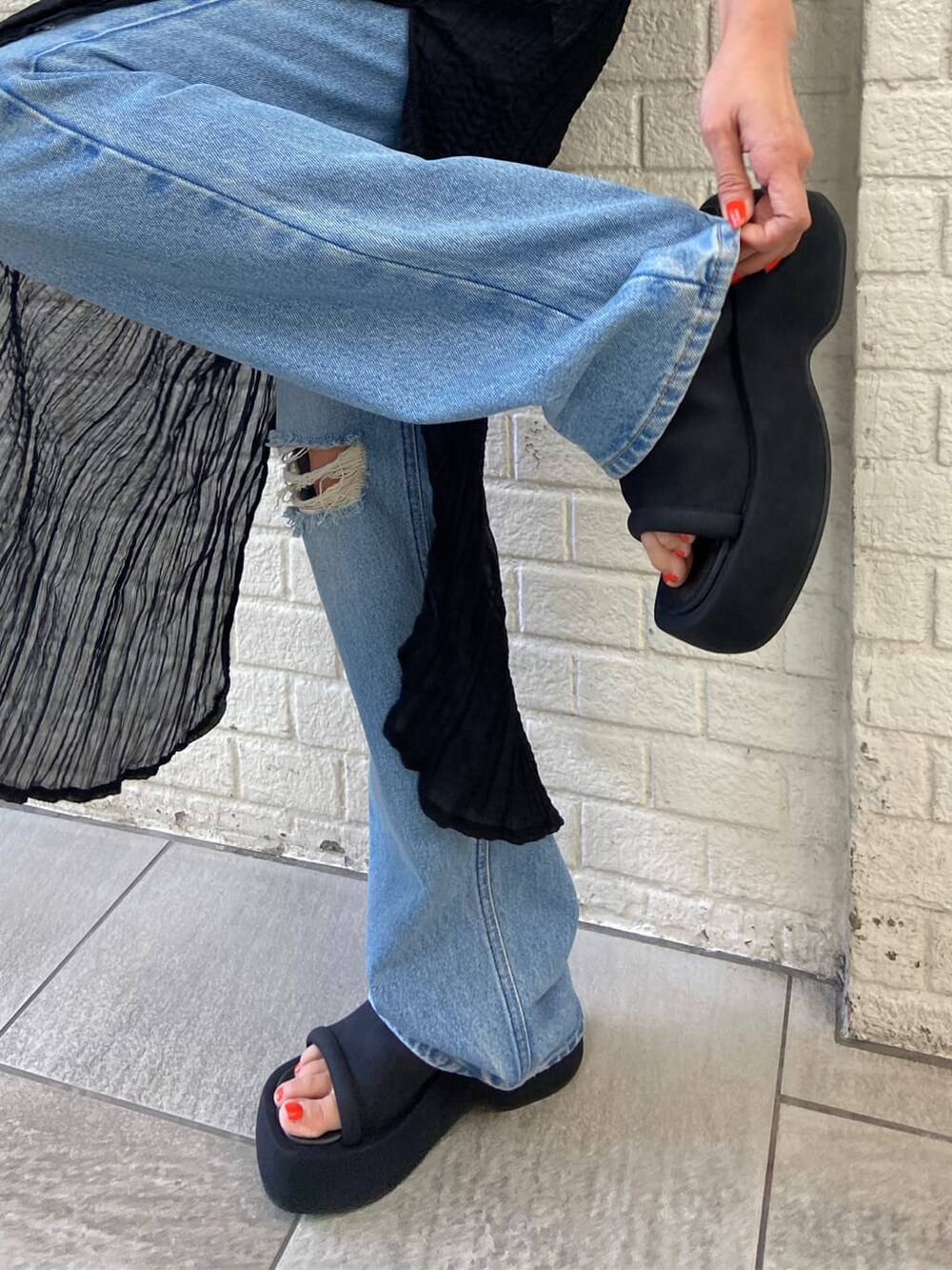 ホワイト系のタンクトップ、ブルー系のデニムパンツ、ブラック系のワンピースを着用したレディースの夏コーディネートの7枚目の写真