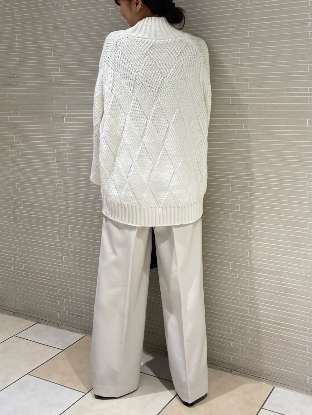 ホワイト系のニット/セーター、ホワイト系のその他パンツ、ブラック系のブーツを着用したレディースの秋コーディネートの4枚目の写真