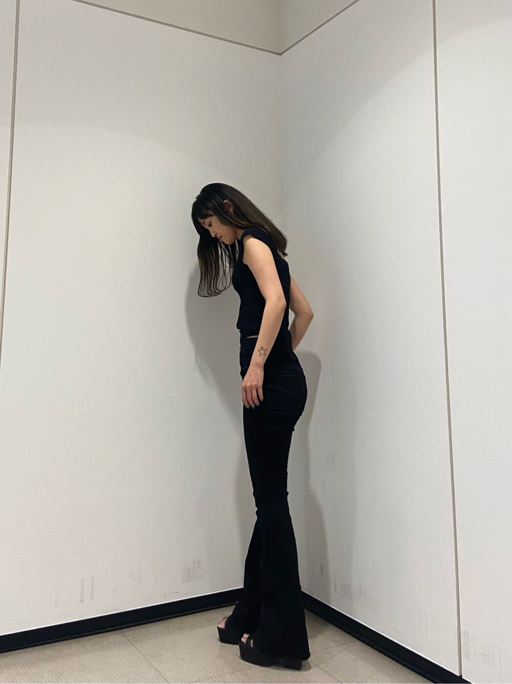 ブラック系のサンダル、ブラック系のデニムパンツ、ブラック系のタンクトップを着用したレディースの夏コーディネートの3枚目の写真