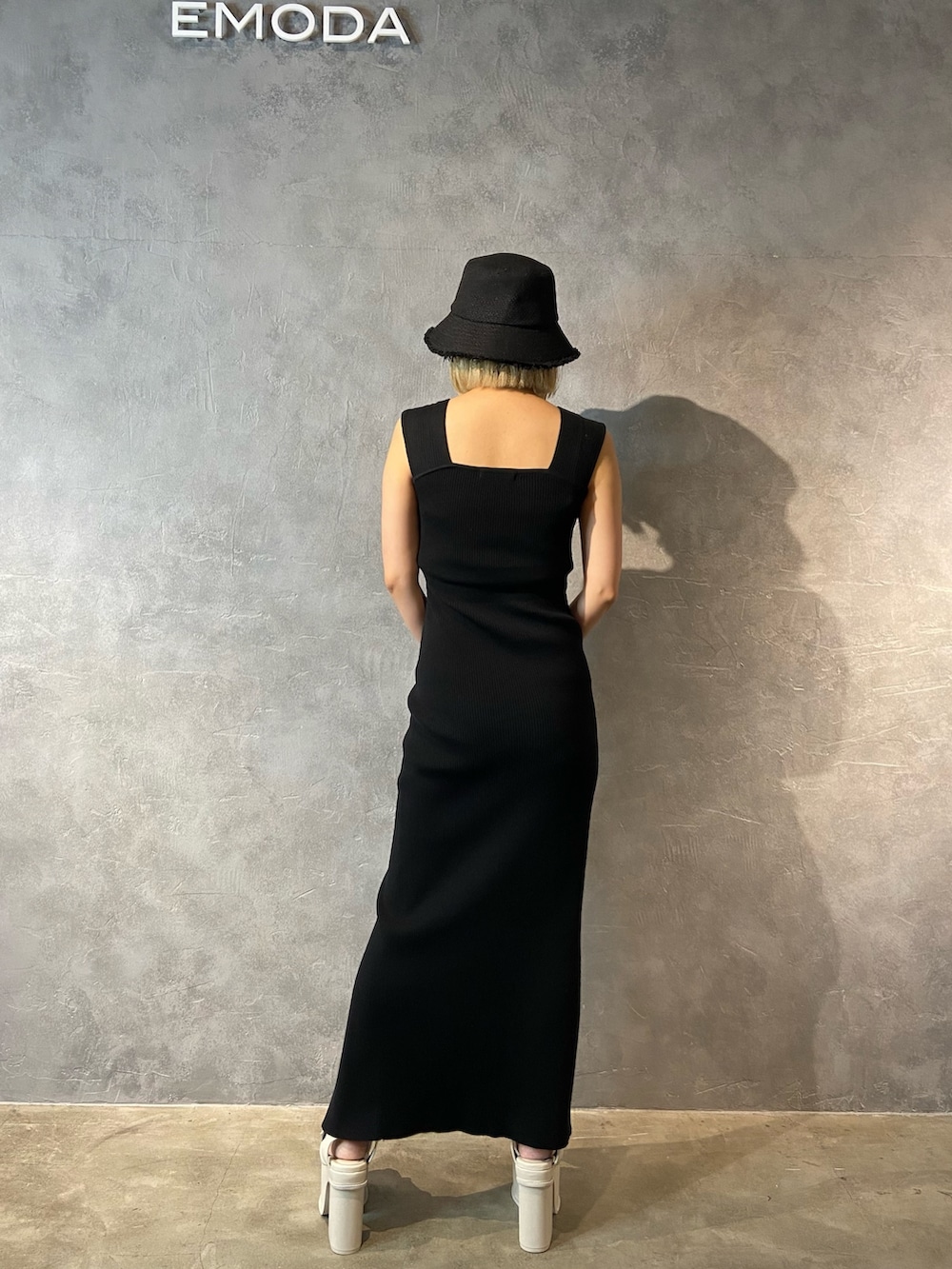 ブラック系のワンピース、ブラック系のショルダーバッグ、ホワイト系のサンダルを着用したレディースの春コーディネートの3枚目の写真