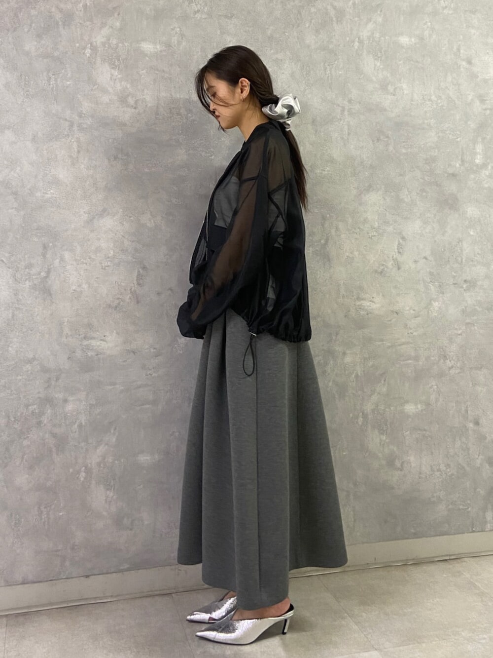 シルバー系のパンプス、ホワイト系のキャミソール、ブラック系のブルゾンを着用したレディースの春コーディネートの3枚目の写真