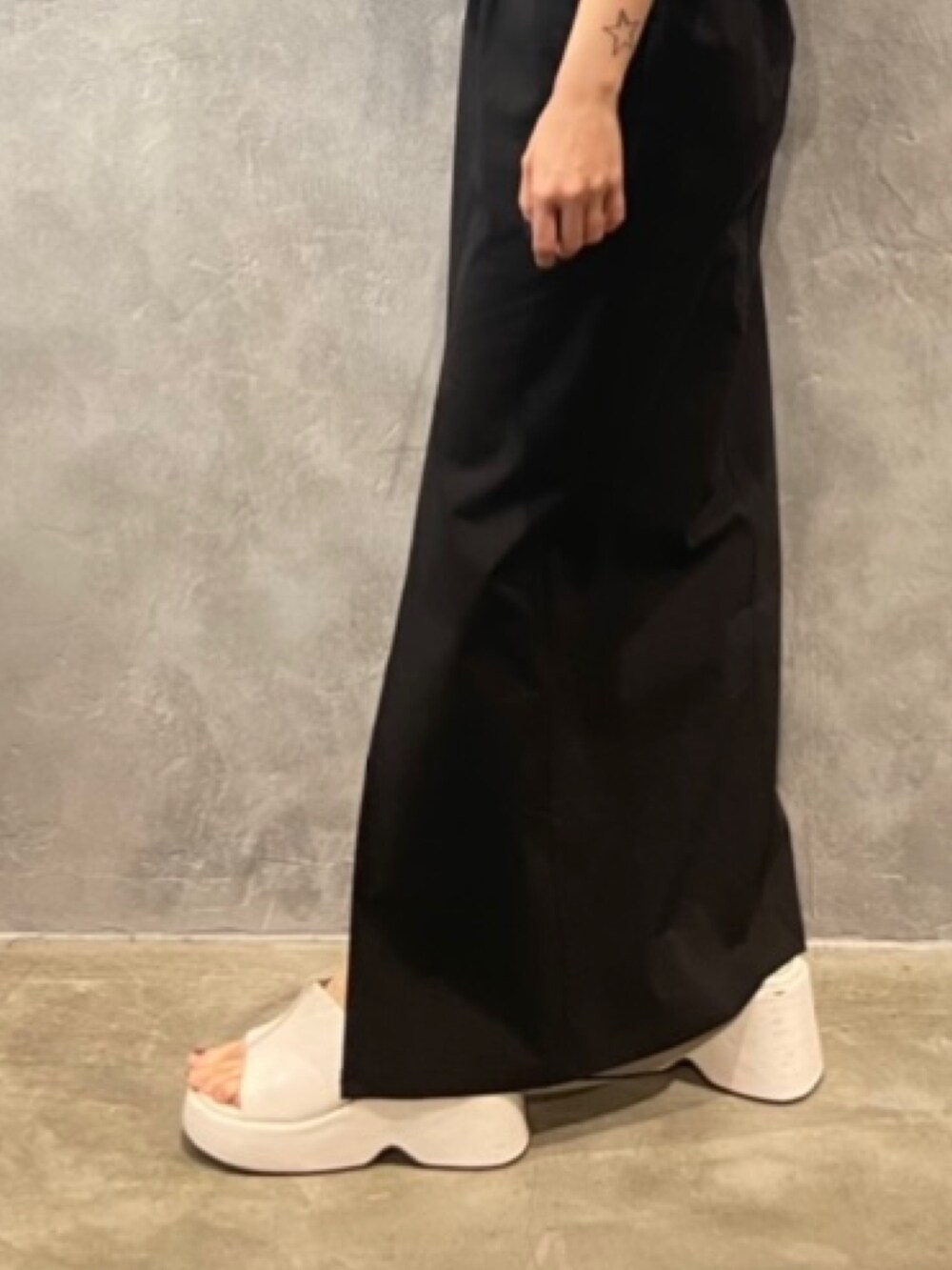 グレー系のTシャツ/カットソー、ホワイト系のサンダル、ブラック系のスカートを着用したレディースの春コーディネートの7枚目の写真