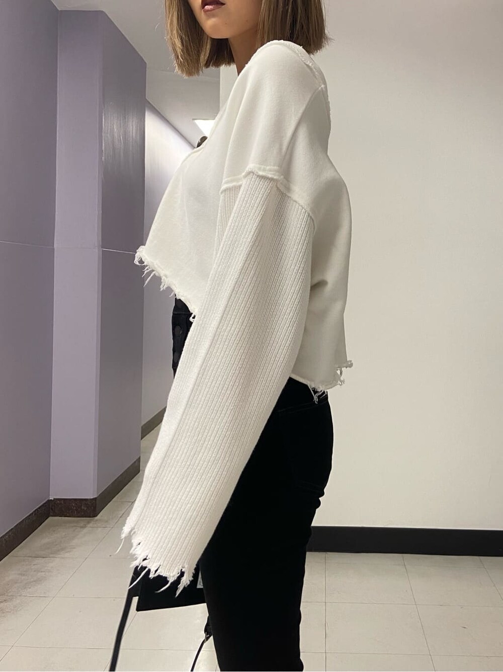 ブラック系のブーツ、ブラック系のハンドバッグ、ホワイト系のカーディガン/ボレロを着用したレディースの秋コーディネートの4枚目の写真