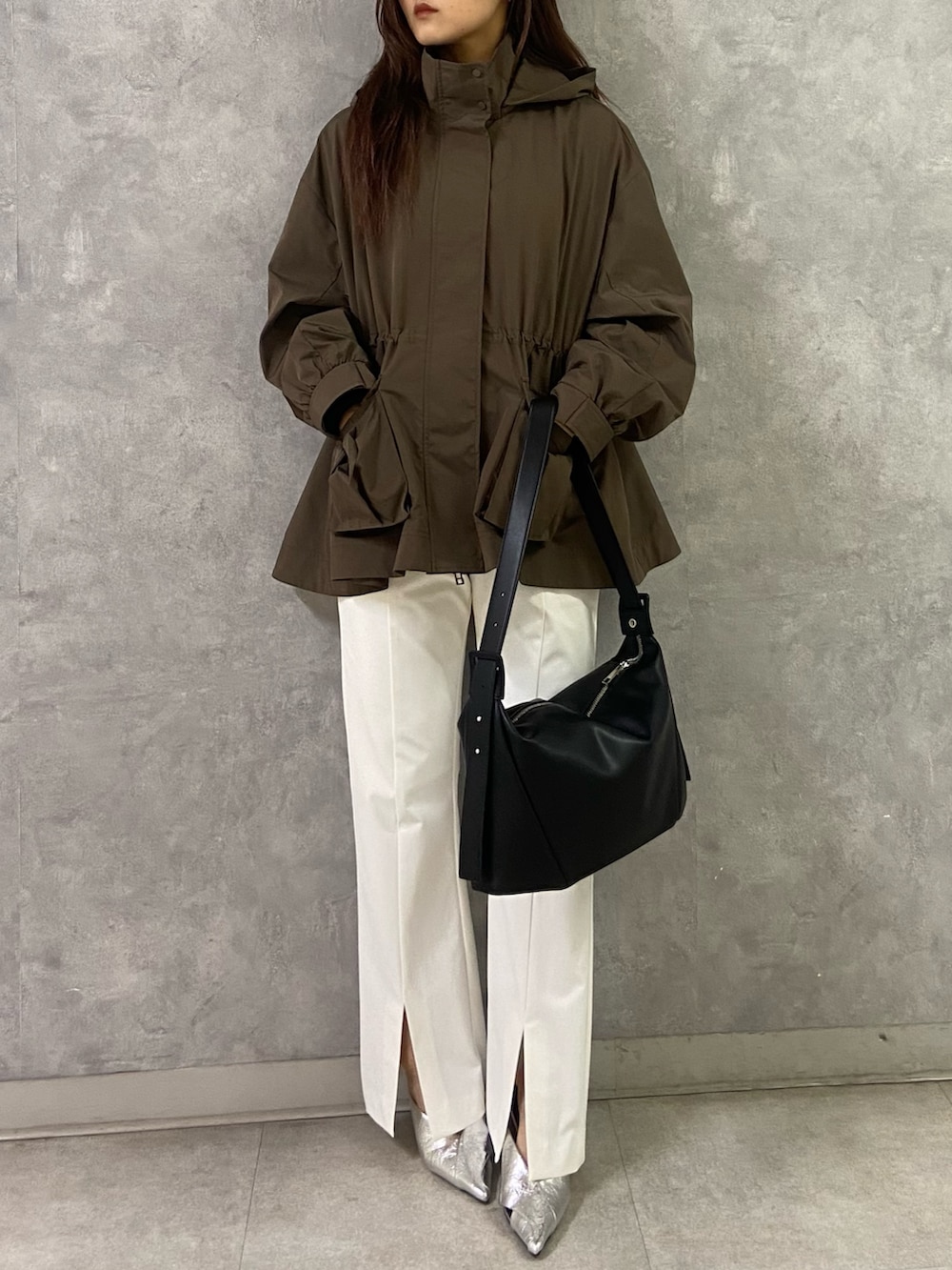 ブラウン系のブルゾン、ブラック系のTシャツ/カットソー、ブラック系のショルダーバッグを着用したレディースの冬コーディネートの6枚目の写真