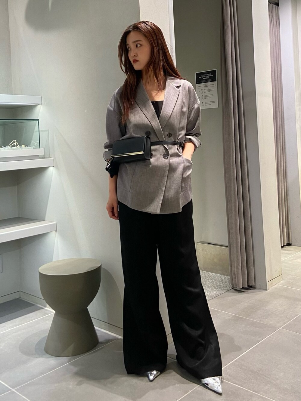 グレー系のテーラードジャケット、ブラック系のショルダーバッグ、ブラック系のその他パンツを着用したレディースの冬コーディネートの2枚目の写真