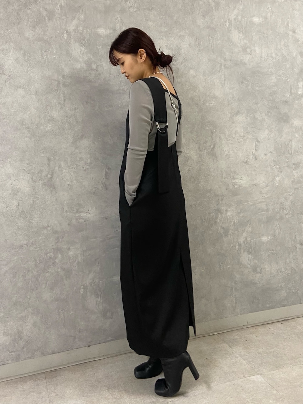 グレー系のTシャツ/カットソー、ブラック系のワンピース、シルバー系のショルダーバッグを着用したレディースの冬コーディネートの2枚目の写真