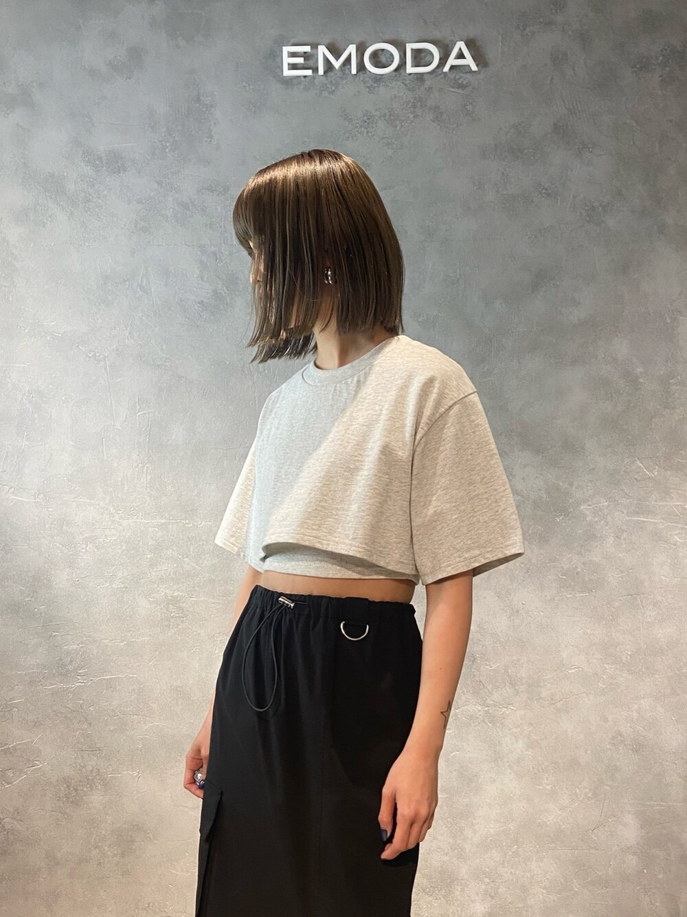 グレー系のTシャツ/カットソー、ホワイト系のサンダル、ブラック系のスカートを着用したレディースの春コーディネートの5枚目の写真